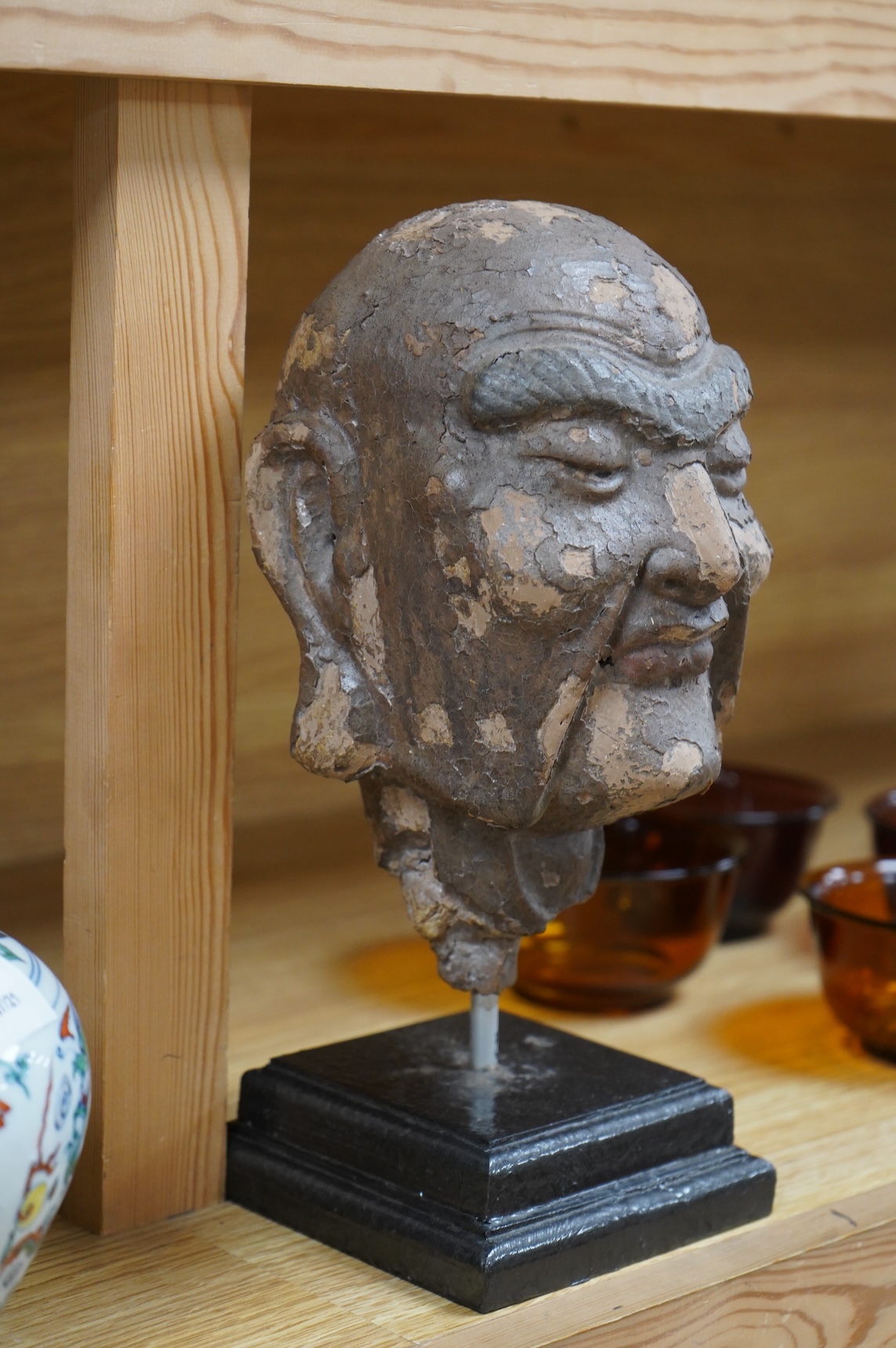 A Chinese lacquered composition head of a Luohan, early Ming, 28cm including stand